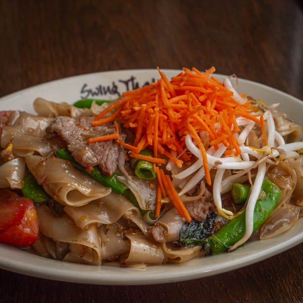 Close-up of Swing Thai Tennyson's Pad See Ew with beef, wide noodles, and fresh vegetables.