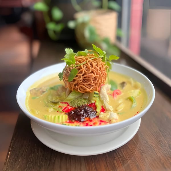Swing Thai Tennyson's yellow curry with chicken, vegetables, and a crispy noodle garnish.